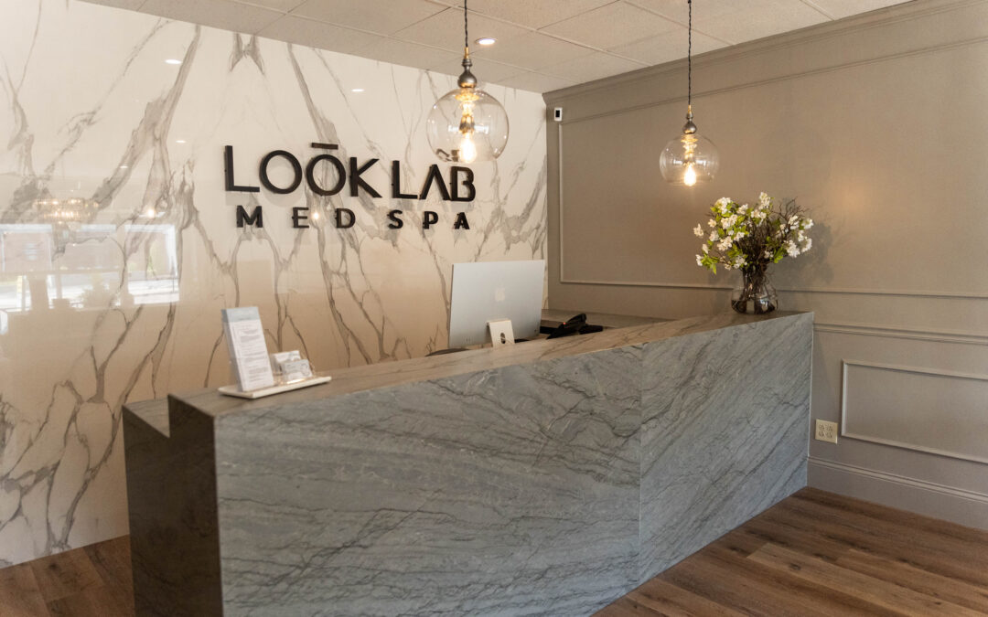 Reception area of Look Lab Med Spa Near Me with marble accent wall and modern decor.