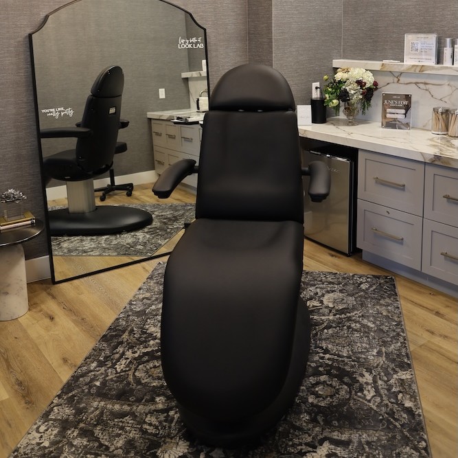 View into one of our plush, sleek treatment spaces at Look Lab. Reclining on a comfortable black treatment chair like one center in this picture, patients receive the best lip filler in Denver.
